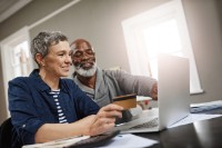 Shot of a senior couple using a credit and laptop while working on their finances at home
